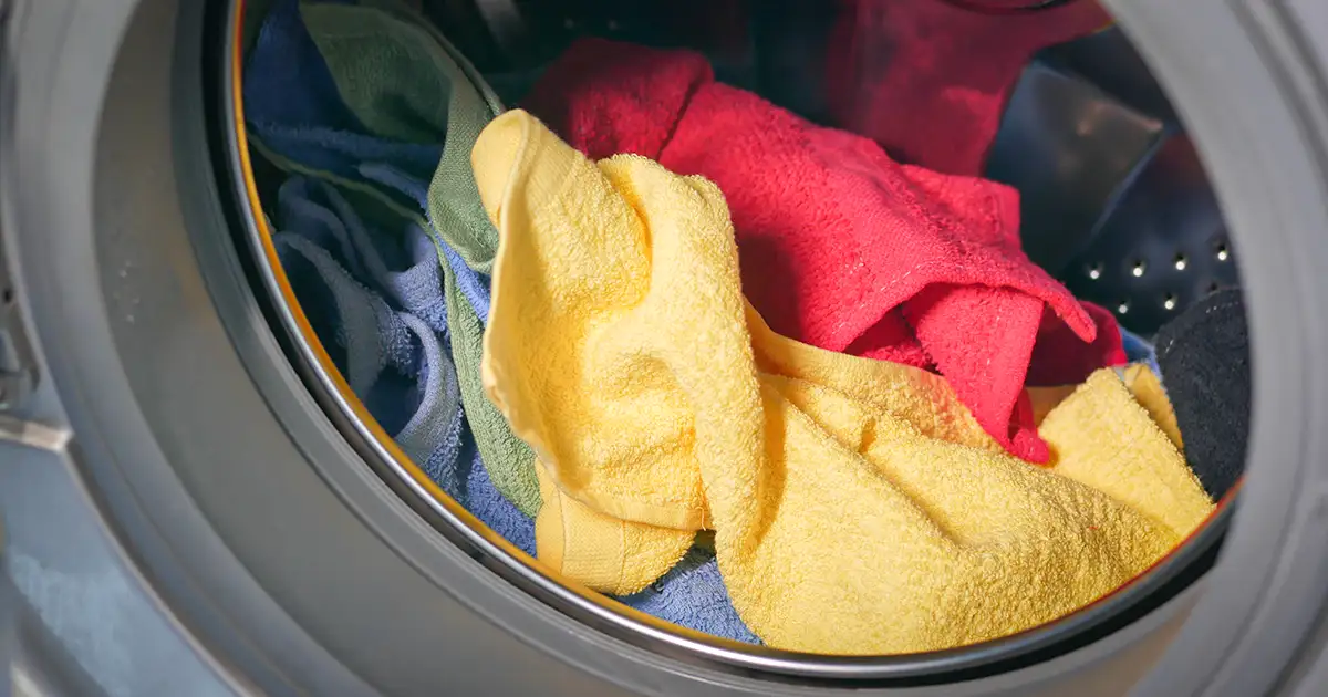 Colorful towels sitting in a clothes dryer.