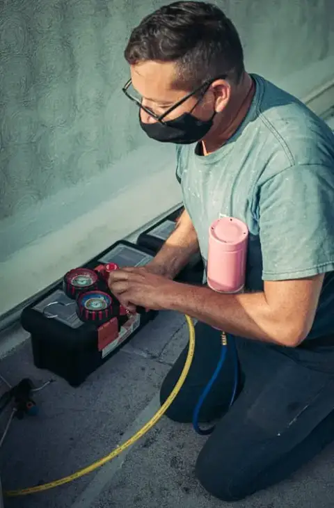 A technician checks the refrigerant levels in a customer's HVAC unit.