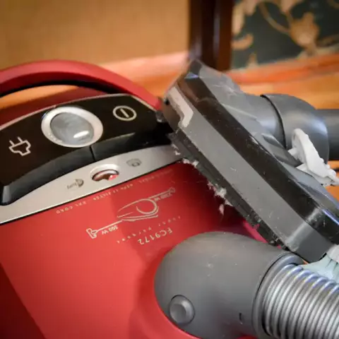 An old fashion vacuum cleaner, with dust all over the power head.