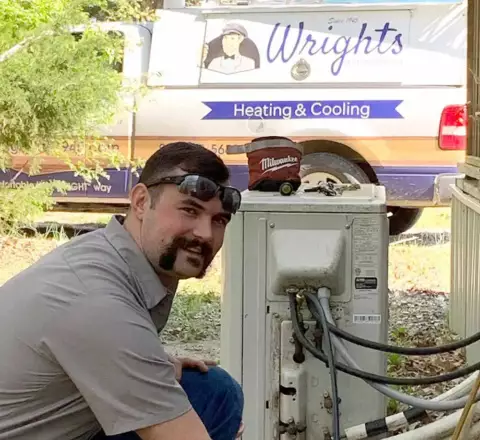 One of Mr. Comfort's technicians at Wright's Air Conditioning hard at work on a customer's HVAC unit.